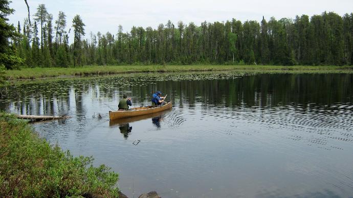 two people in a canoe on a lake