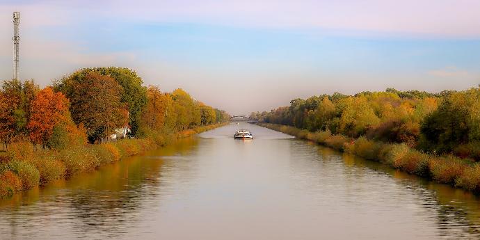 white boat on river between green trees during daytime